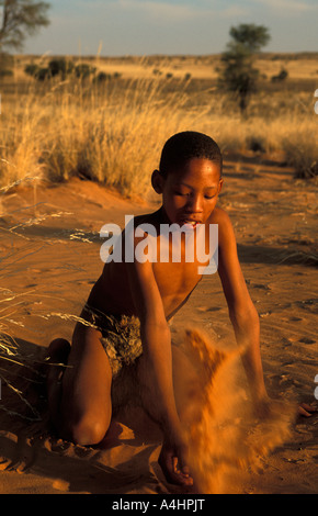 Bushman San boy playing in the sand Kalahari Northern Cape South Africa Stock Photo