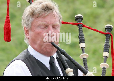adult male playing bagpipes at Dundonald Highland Games, Ayrshire, Scotland