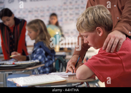 teacher helping middle school student in class Stock Photo