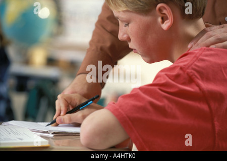 teacher helping middle school student in class Stock Photo