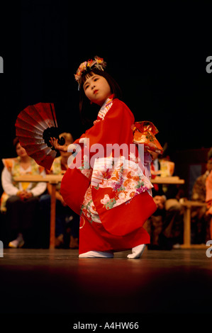 Young Japanese Girl Dancer from Ikuta Shinto Shrine in Japan wearing a Kimono and dancing Traditional Dance Performance on Stage Stock Photo