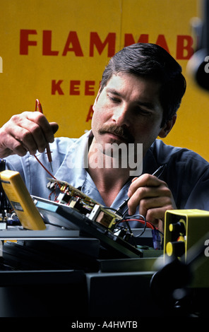 Portrait Technician checking electronic equipment with voltmeter Stock Photo