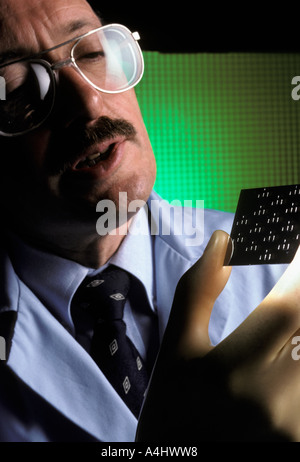 portrait Scientist demonstrating micro electronic device using thin film technology Stock Photo