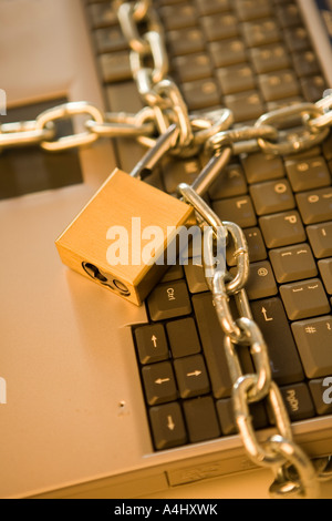 Portable computer wrapped in chains Stock Photo