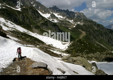 Female walker walking across a snow covered on a path in Chamonix France Stock Photo