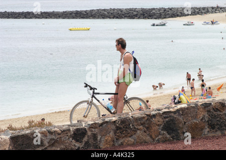 Cyclist spying on beach below Stock Photo - Alamy