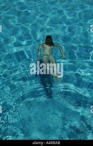 Woman in bikini swimming underwater in a pool Stock Photo