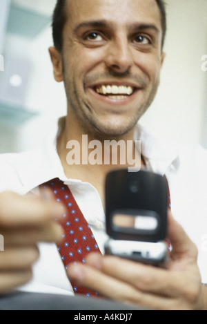 Man using cell phone, smiling Stock Photo