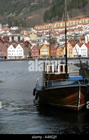 A boat at port, shop fronts and houses at the coast in Bergen Norway. Stock Photo