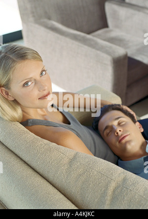 Man sleeping with head on woman's lap Stock Photo