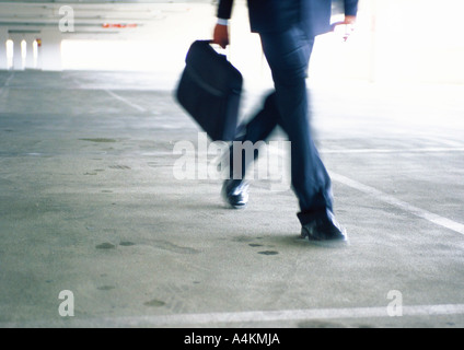 Businessman walking, lower section, blurred Stock Photo