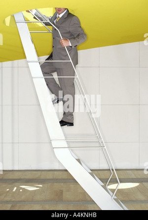 Man in suit, standing on stairs Stock Photo