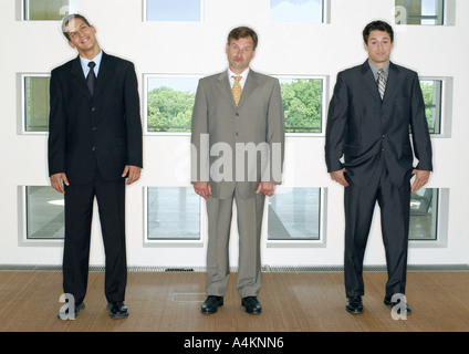 Three businessmen standing in a line Stock Photo