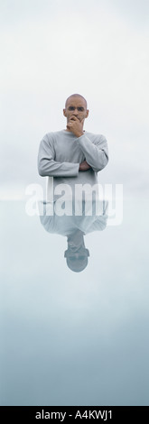 Man standing in front of table with his reflection, outdoors Stock Photo