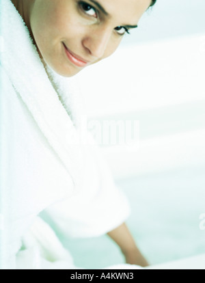 Woman in bathrobe looking at camera, partial view Stock Photo