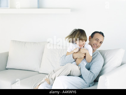 Father holding son on sofa Stock Photo