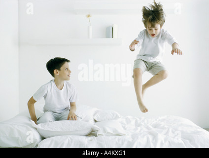 Boys on bed, one in mid air Stock Photo