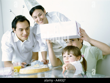 Boy and girl with parents having birthday party Stock Photo