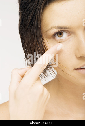 Woman inserting contact lense, close-up Stock Photo