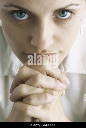 Woman with hands clasped under chin, portrait Stock Photo