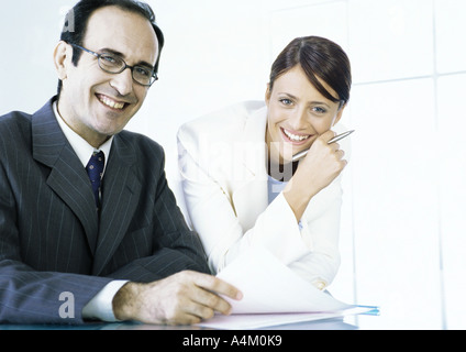 Businessman and businesswoman with documents smiling at camera Stock Photo