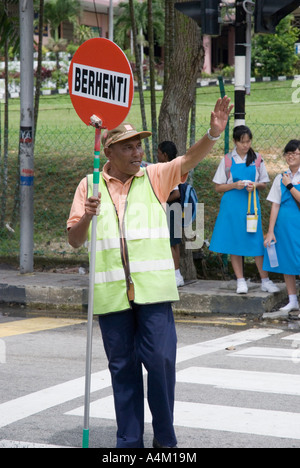 A Malaysian school crossing guard outside a Christian girls high school in Johor Bahru Malaysia Stock Photo