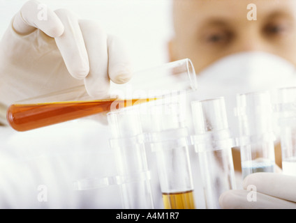 Man transferring contents of test tube Stock Photo