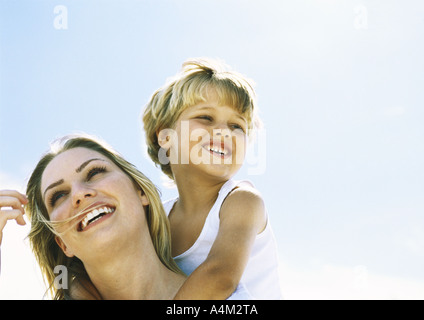 Boy and mother, boy behind mother with arms around her neck, portrait Stock Photo