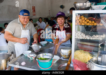 A chef preparing laksa and noodles at a restaurant in Ipoh Malaysia Stock Photo