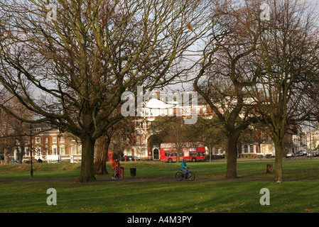 children Learning cycling and enjoying Autumn leave and trees in Clapham common in London England UK Stock Photo