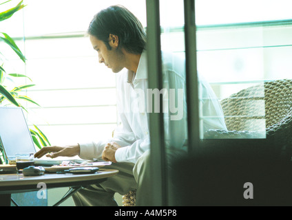 Man using laptop on terrace Stock Photo
