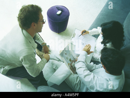Young adults examining designs, high angle view Stock Photo