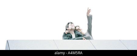 Young couple at rooftop edge admiring view, low angle view Stock Photo