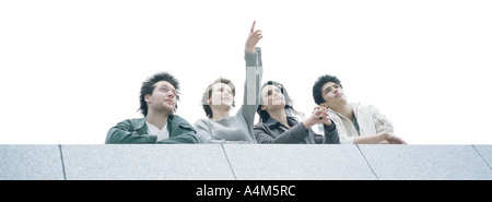 Young people at rooftop edge admiring view, low angle view Stock Photo