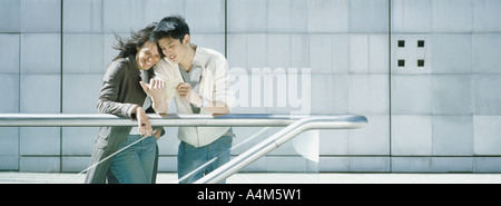 Young couple leaning against rail Stock Photo