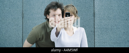 Young couple taking self portrait with camera phone Stock Photo