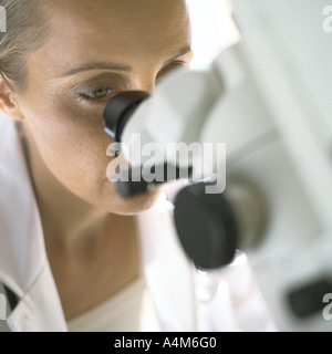 Doctor looking through microscope Stock Photo