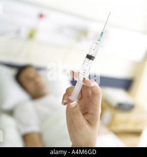 Syringe being held up in front of patient