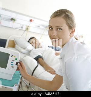 Nurse checking patient's monitor Stock Photo