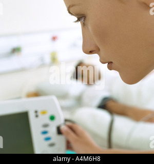 Nurse checking patient's monitor Stock Photo