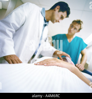 Doctors standing over patient Stock Photo