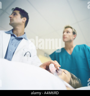 Doctors standing over patient Stock Photo