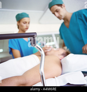 Interns standing over patient Stock Photo