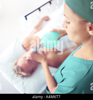 Female doctor holding oxygen mask over patient's face, high angle view Stock Photo