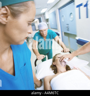 Medical team moving patient on gurney Stock Photo