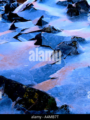 sea ice on the shores of Loch Leven reflecting sunlight from the opposite shore Stock Photo