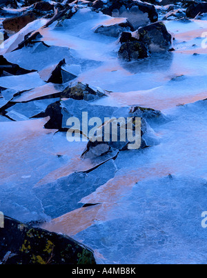 sea ice on the shores of Loch Leven reflecting sunlight from the opposite shore Stock Photo