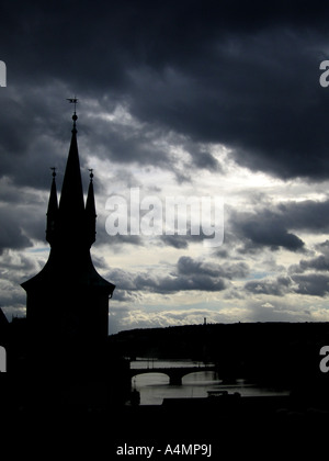 Church silhouette with stormy cloudy sky and bridges over River Vlatva Prague Czech Republic Prague Stock Photo