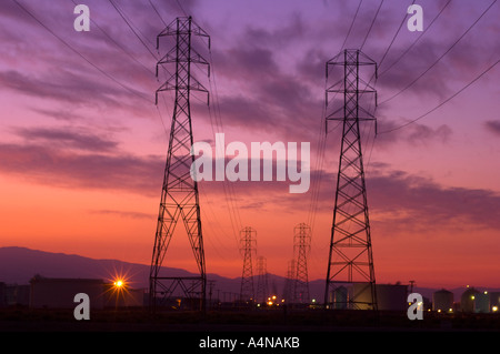 Rows Of Electrical Power Lines At Sunrise Sunset Golden Sky Stock Photo