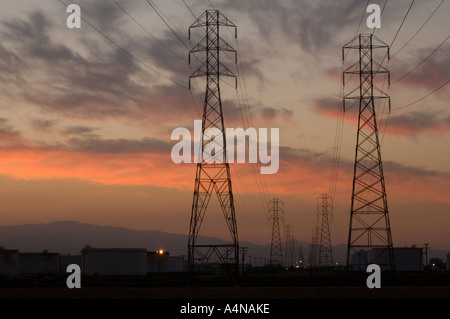 Rows Of Electrical Power Lines At Sunrise Sunset Golden Sky Stock Photo